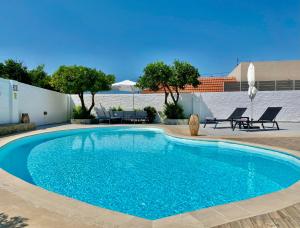 a swimming pool with blue water in a yard at Villa Elena - Private Villa in the heart of nature in Chania Town