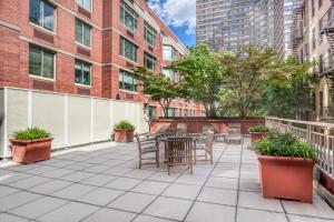 un patio con tavolo, sedie e edifici di UWS 1br w doorman gym nr Central Park NYC-932 a New York