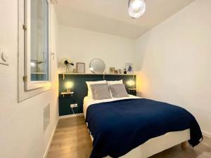 une chambre avec un grand lit avec des draps bleus dans l'établissement Le Jardin - Calme et Confort - Lac de Nantua, à Nantua