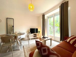 uma sala de estar com um sofá e uma mesa em Le Jardin - Calme et Confort - Lac de Nantua em Nantua