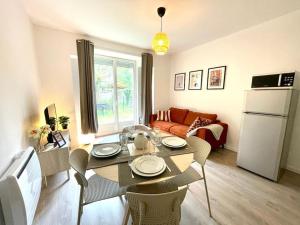 un salon avec une table avec des chaises et un canapé dans l'établissement Le Jardin - Calme et Confort - Lac de Nantua, à Nantua 7 autres photos