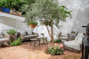 un patio con un árbol, sillas y una mesa en Carme -Alojamiento céntrico en Girona, en Girona