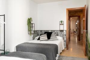 1 dormitorio con 1 cama con cabecero blanco y negro en Carme -Alojamiento céntrico en Girona, en Girona