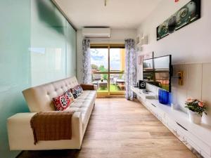 uma sala de estar com um sofá e uma televisão em OleHolidays 1113 Romana Playa vistas al mar em Marbella