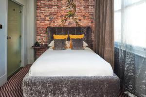 a bed in a room with a brick wall at Malmaison London in London