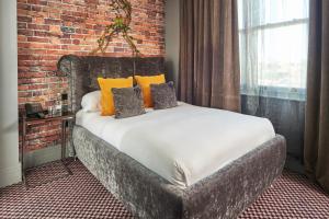 a bed in a room with a brick wall at Malmaison London in London +37 photos