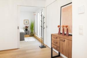 een woonkamer met een dressoir en een spiegel bij SkyLine Apartment mit Terrasse close to Lakes in Wenen