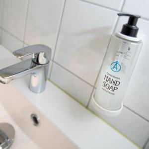 a bottle of hand soap sitting on a bathroom sink at Hotel Adlon in Mariehamn