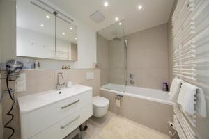 een badkamer met een wastafel, een toilet en een bad bij SkyLine Apartment mit Terrasse close to Lakes in Wenen