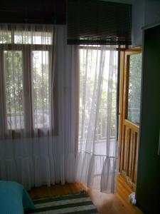Habitación con ventanas grandes y cortinas blancas. en Wohnung(en) zwischen Meer und Bergen, en Özdere