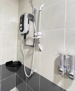 a shower in a bathroom with a hair dryer on a wall at FuYoke Emerald Avenue @ Brinchang in Cameron Highlands