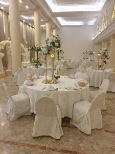 une salle de banquet avec des tables blanches et des chaises blanches dans l'établissement Riviera Hotel and Beach Lounge, Beirut, à Beyrouth