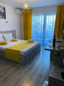 a bedroom with a large bed with a yellow blanket at MAV Boutique Villa in Eforie Nord