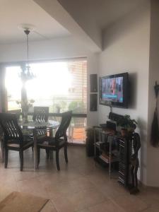 a dining room with a table and chairs and a tv at Ravda Sun Sea Ressort 2 in Ravda