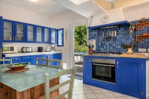 Ca Na Loulou في كالا ذاور: مطبخ مع دواليب زرقاء وقمة زرقاء
