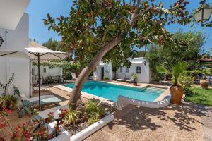 a swimming pool in a yard with a tree at Ca Na Loulou in Cala d´Or