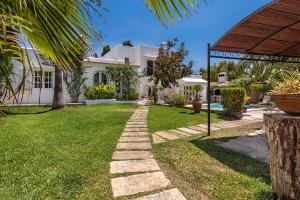 a garden with a pathway in front of a house at Ca Na Loulou in Cala d´Or