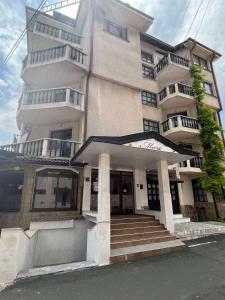 a large building with stairs in front of it at Апарт Хотел Мари in Ravda +7 photos