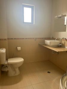 a bathroom with a toilet and a sink at Апарт Хотел Мари in Ravda