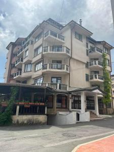 a large building with balconies on the side of it at Апарт Хотел Мари in Ravda