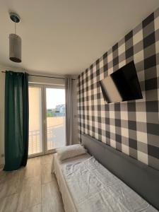 1 dormitorio con 1 cama y TV en la pared en Willa Koralowa 16 - BASEN PODGRZEWANY, KLIMATYZACJA en Sarbinowo