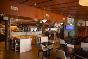 a restaurant with tables and chairs and a bar at Hotel Adlon in Mariehamn