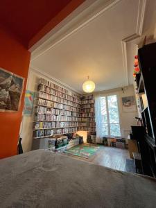 una sala de estar con una gran pared de libros. en Apartment near Montmartre(2 rooms!) en París