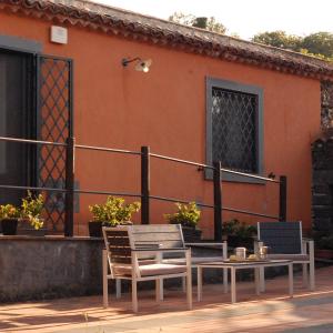 un patio con 2 sillas y una mesa y un edificio en La casa di Bacco - Etna Country House - Affitto breve, en Castiglione di Sicilia