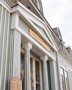 un bâtiment avec des colonnes blanches et un panneau sur celui-ci dans l'établissement Johanssonin talo 1849, à Joensuu