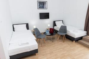 um quarto com duas camas e uma mesa e cadeiras em Hotel Tor Kielce em Kielce
