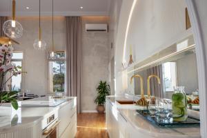a kitchen with white counters and gold faucets at La Torre Residenza Imperiale in Chania