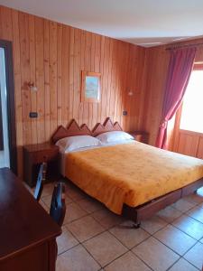 Schlafzimmer mit einem großen Bett und Holzwänden in der Unterkunft Locanda Lac Place Moulin in Bionaz