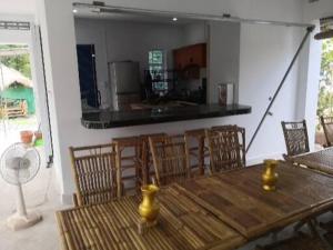 uma sala de jantar com uma mesa de madeira e cadeiras em Pottery Garden Villa em Phumĭ Dêk Dŏl