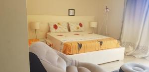 a bedroom with a bed and a chair in it at LA vista 6 topaz in Ain Sokhna