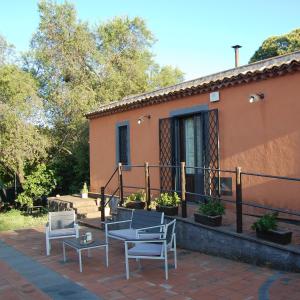 un patio con 2 sillas, una mesa y una casa en La casa di Bacco - Etna Country House - Affitto breve, en Castiglione di Sicilia
