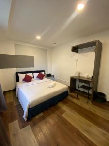 a bedroom with a large bed and a desk at V Hotel Johor Bahru in Johor Bahru