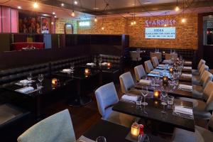 a restaurant with tables and chairs and a bar at Malmaison London in London
