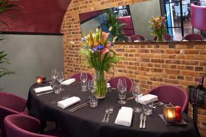 a table in a restaurant with a vase of flowers at Malmaison London in London