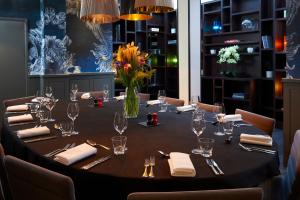 a table with glasses and napkins and a vase of flowers at Malmaison London in London