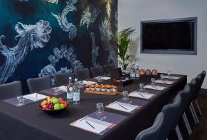 a long meeting room with a long table with a bowl of fruit at Malmaison London in London