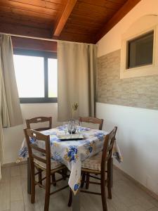 uma sala de jantar com uma mesa e cadeiras e uma janela em Spiaggia Le Dune Residence em Margherita di Savoia