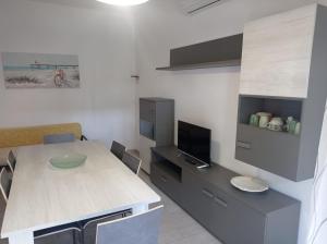 a kitchen with a table and a desk with a tv at Residence Miami in Lido di Spina