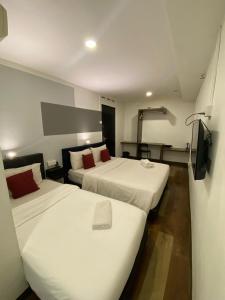 a hotel room with two beds and a flat screen tv at V Hotel Johor Bahru in Johor Bahru