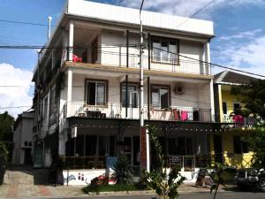 un grande edificio bianco con un balcone su una strada di Гостевой дом при кафе оазис a Kobuleti