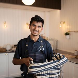 a man in a kitchen holding a towel at Hotel Adlon in Mariehamn