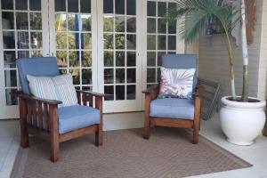 twee stoelen en een plant op een veranda bij The Symphony in Durban