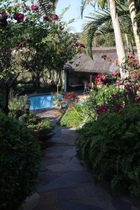 een tuin met een loopbrug en bloemen en een huis bij The Symphony in Durban