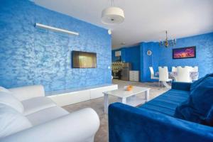 uma sala de estar com paredes azuis e um sofá azul em Redondo Apartments Budva em Budva