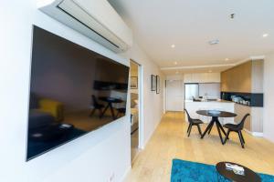 uma cozinha e uma sala de estar com mesa e cadeiras em Modern 1 Bed Opposite Racecourse em Melbourne