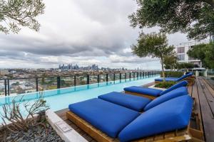 uma piscina com almofadas azuis no topo de um edifício em Modern 1 Bed Opposite Racecourse em Melbourne